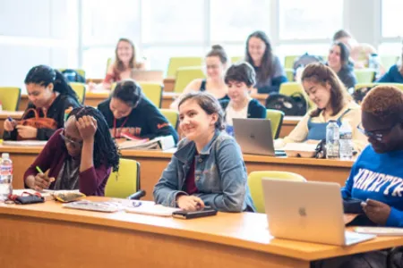 Students with laptops in a classroom learning