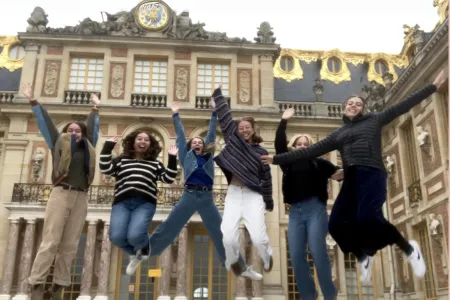 Sophie and 5 friends jumping in front of a palace courtyard