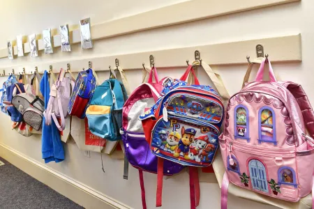 A row of backpacks on hooks