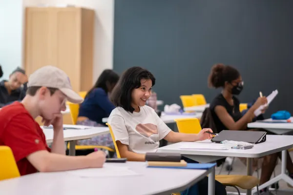 student smiling at desk