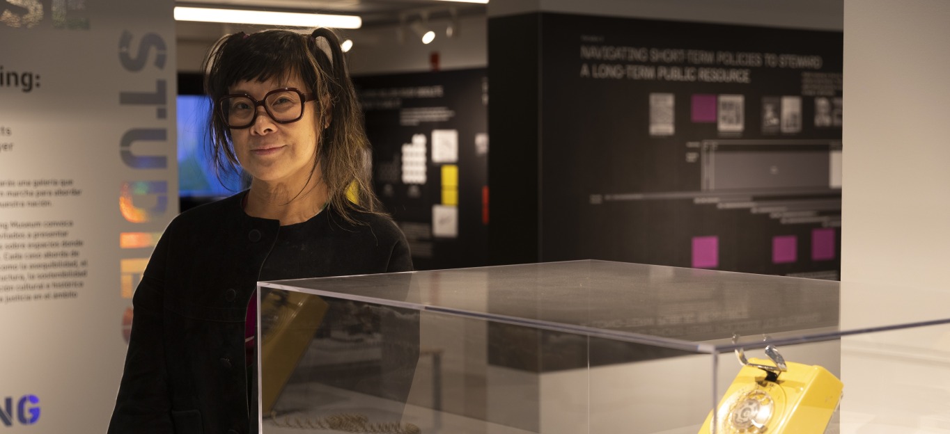 Lisa Yun Lee ’91 beside a rotary phone on display at the National Public Housing Museum