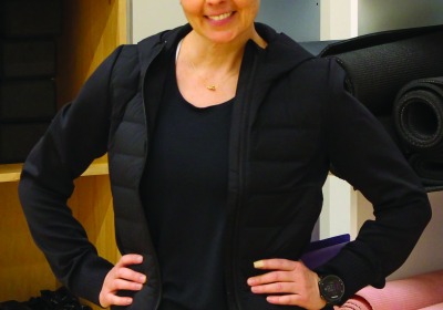 Portrait of Courtney Morris in front of a shelf full of yoga mats