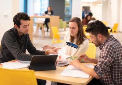 Three students sitting around a table studying