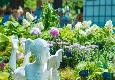 Statue of a girl surrounded by blooming flowers