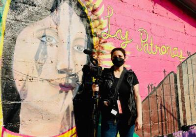 Tania Romero at Las Patronas, in front of a wall mural