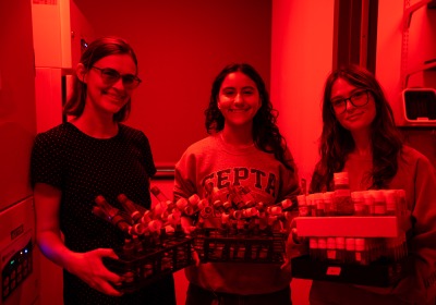 Hannah Shoenhard in her red-lit lab with students