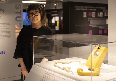 Lisa Yun Lee ’91 beside a rotary phone on display at the National Public Housing Museum