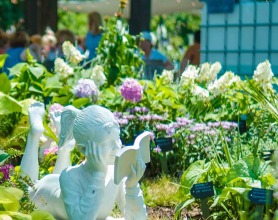 Statue of a girl surrounded by blooming flowers