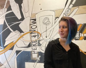 Allaina Propst sitting in front of a mural