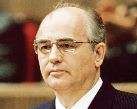 Mikhail Gorbachev seated behind microphones