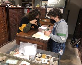 Artist and student look at empty boxes that remain from the uranium once stored in the collection.