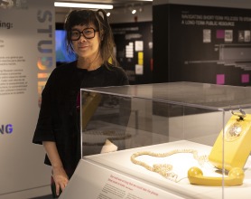 Lisa Yun Lee ’91 beside a rotary phone on display at the National Public Housing Museum