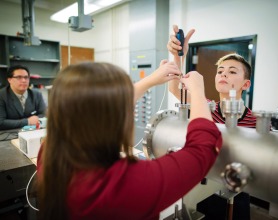 Working closely with Dr. David Schaffner in setting up the lab are Emmeline Douglas-Mann ’18 and Ph.D. candidate Carlos Cartagena. Physics professor and students working in a lab.