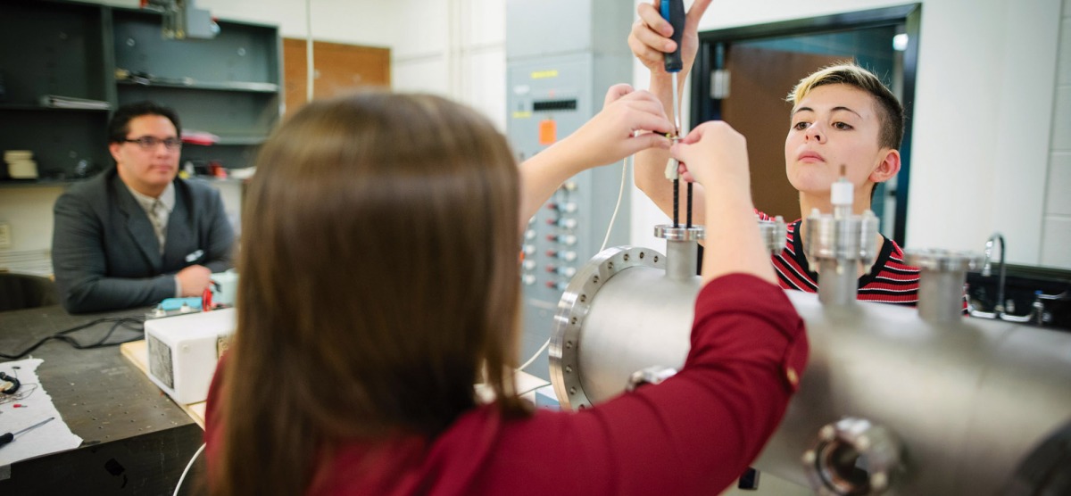 Physics professor and students working in a lab.