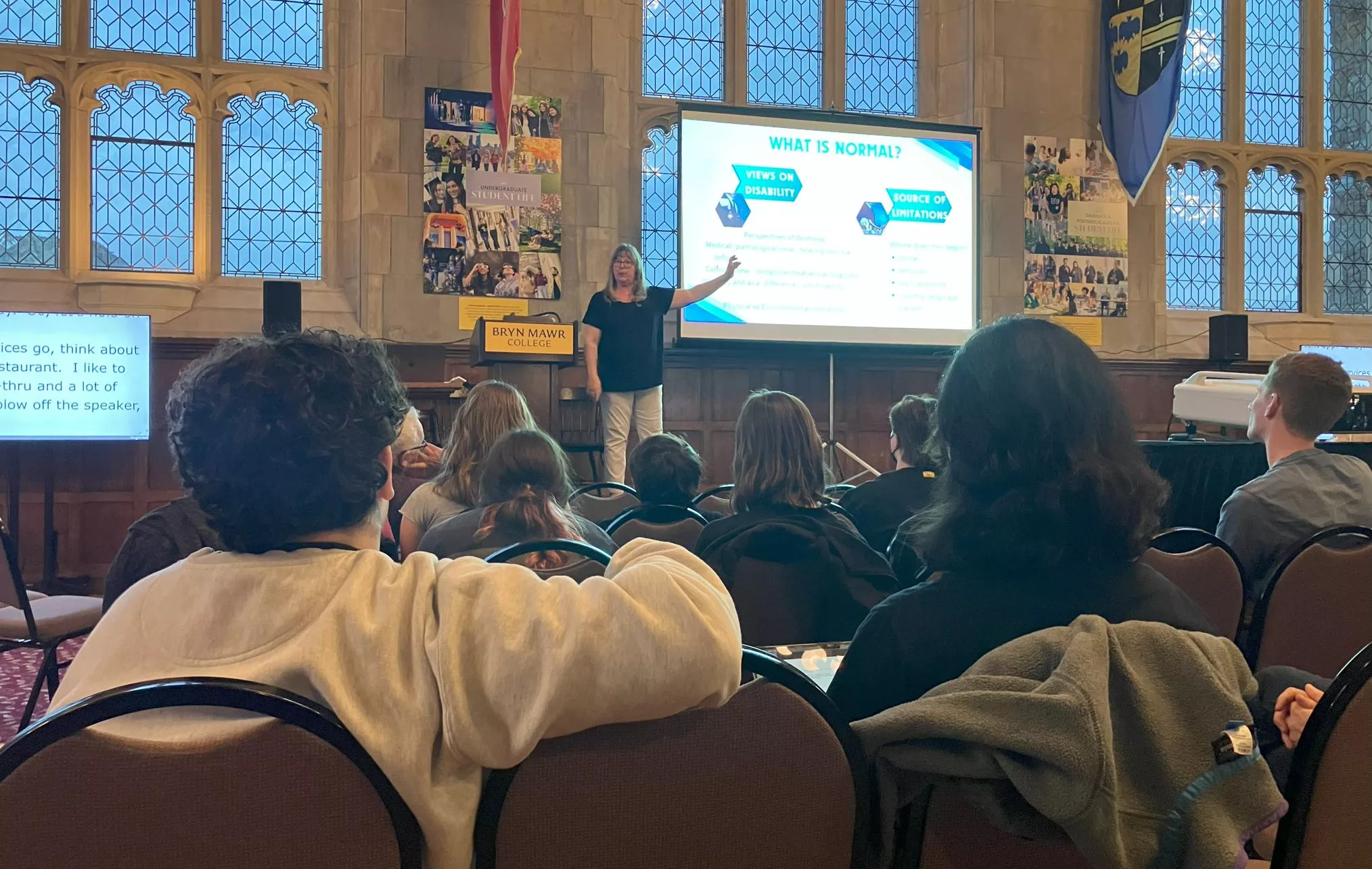 Melanie Drolsbaugh presents on stage at the Great Hall.