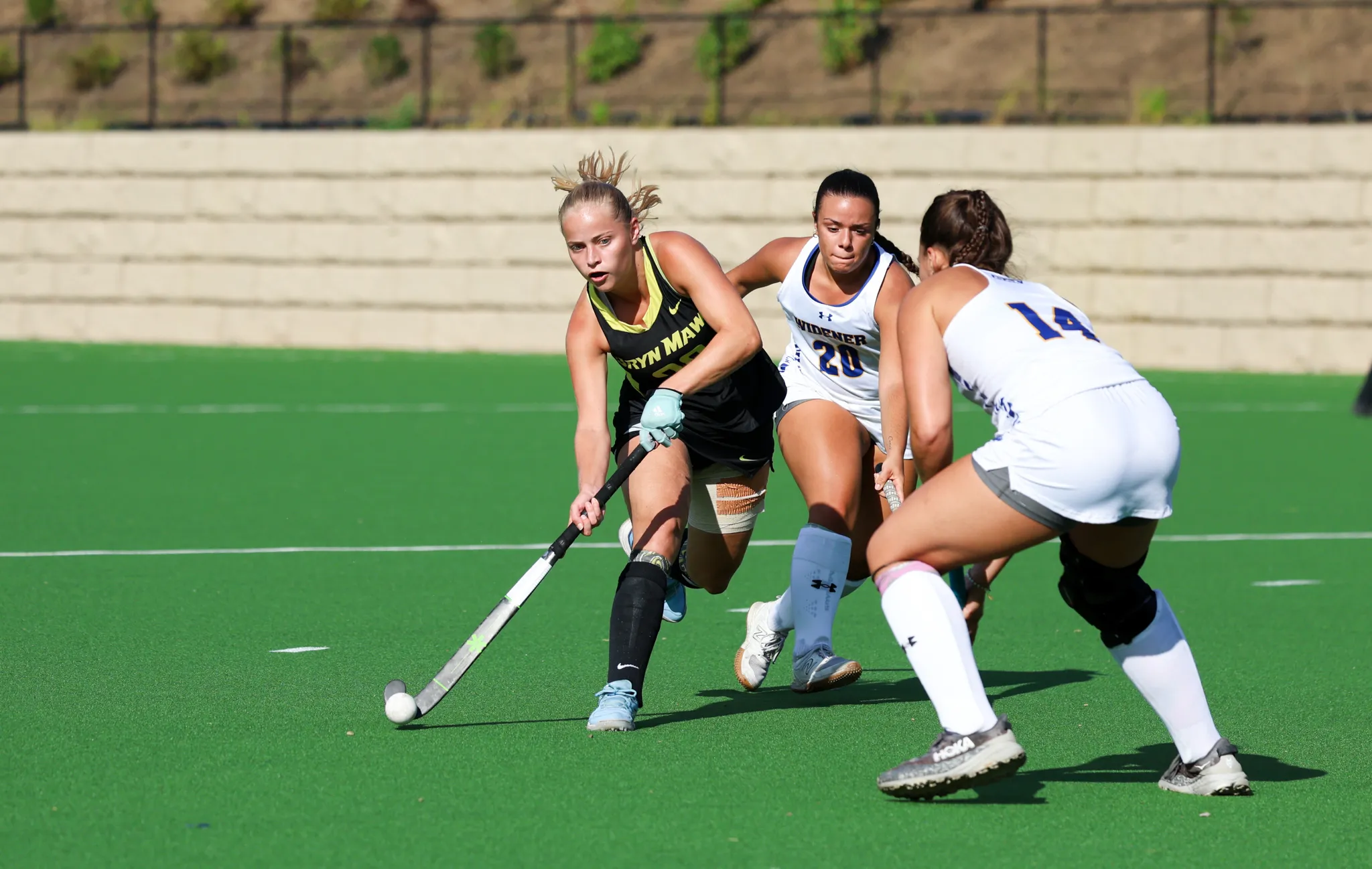 Three field hockey players on the field