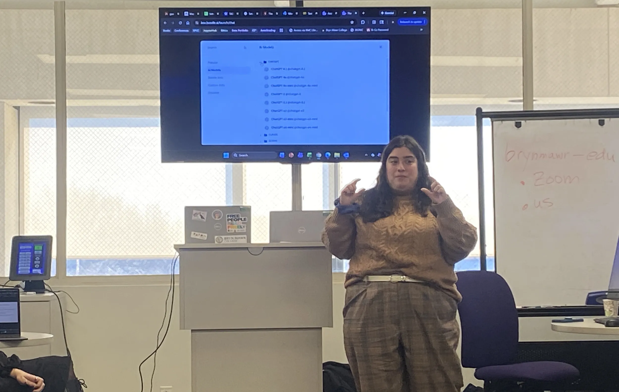 Alyssa Pivirotto stands behind a screen showing different chatbot models in Boodlebox