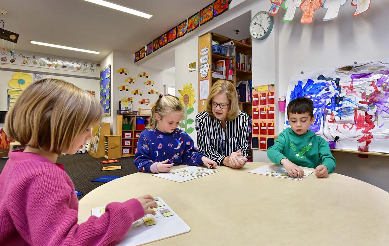 Students at table with teacher 