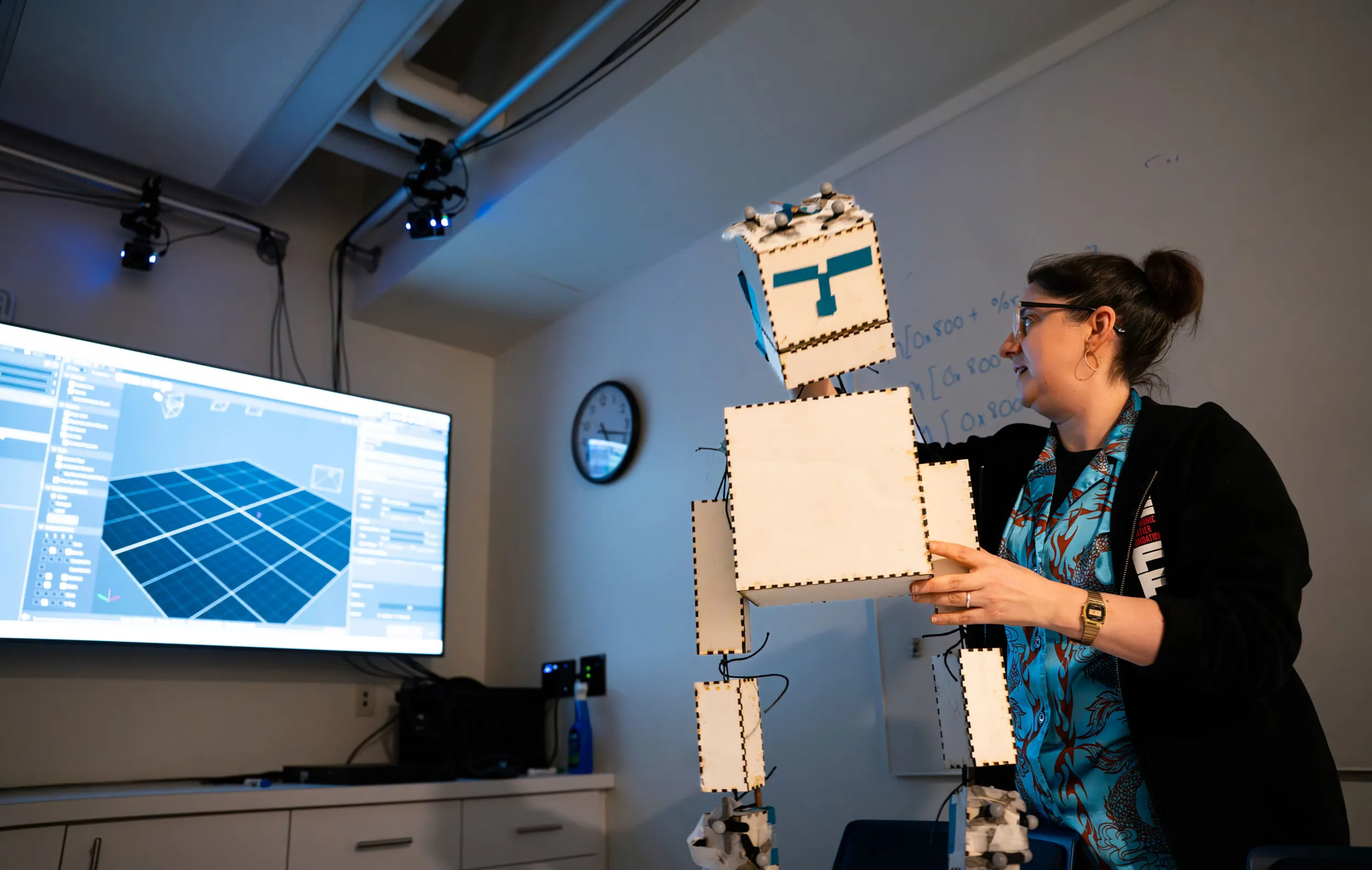 Professor Aline Normoyle manipulates a cardboard puppet in front of a computer screen