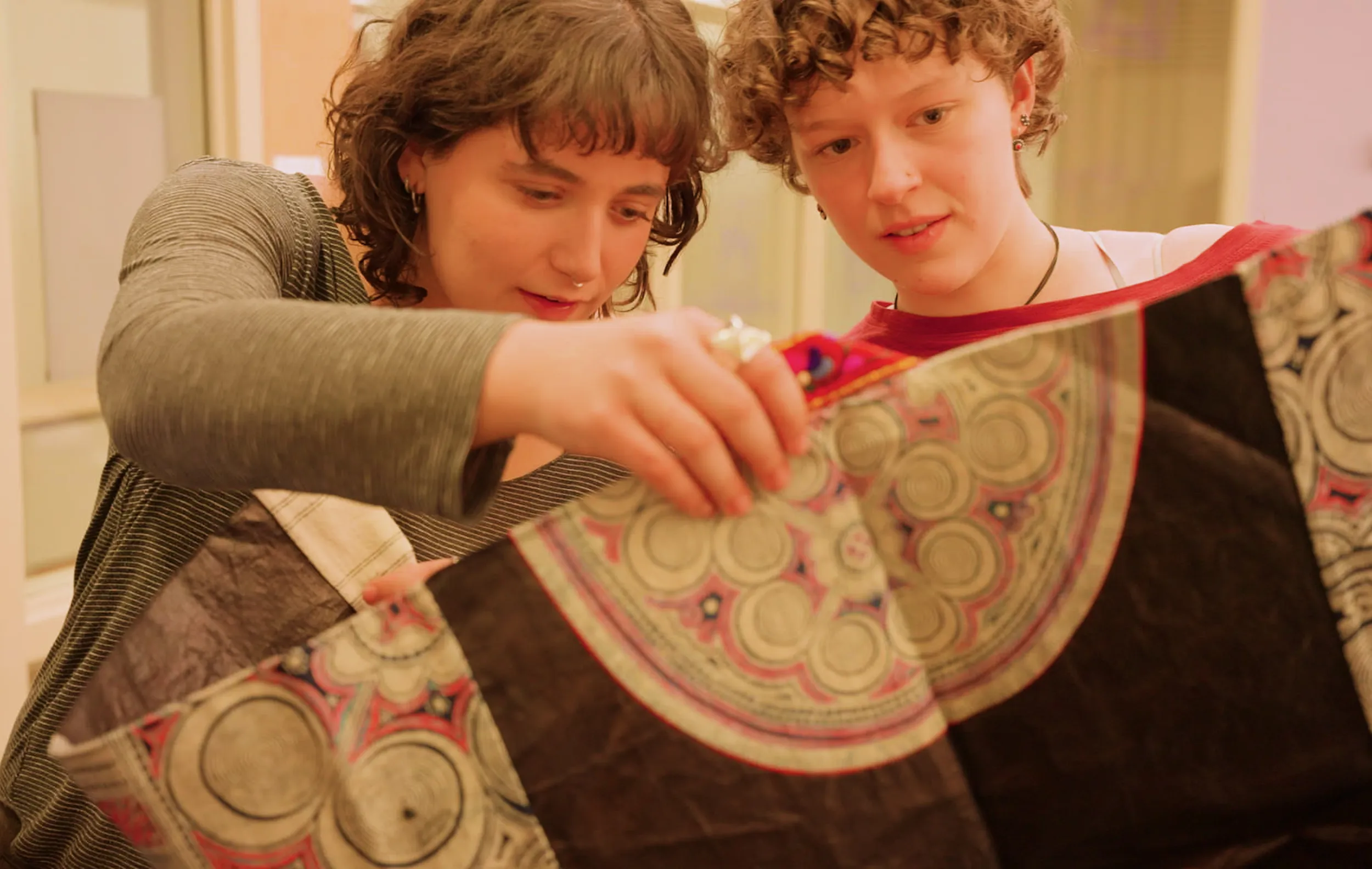 Two Bryn Mawr College Art History students examine a cloth in Special Collections