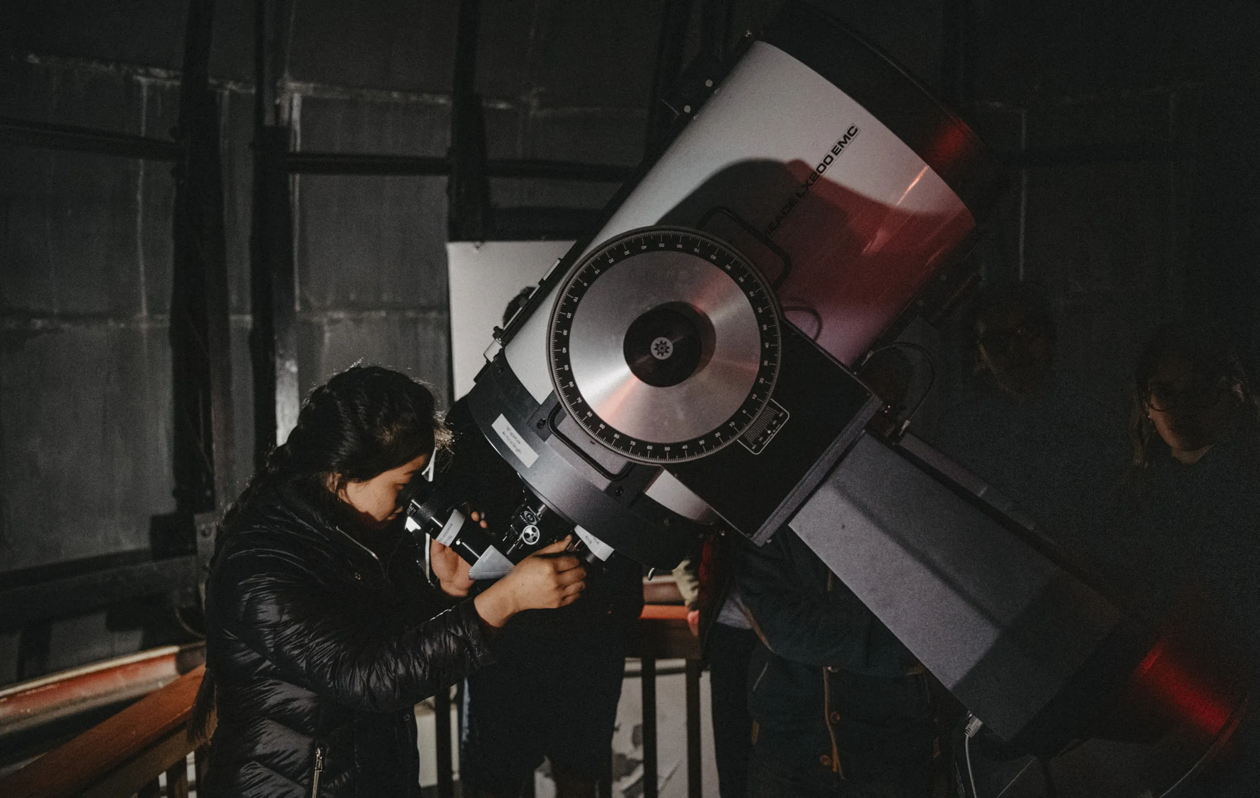 A Bi-College student looks through the telescope at the Haverford College observatory