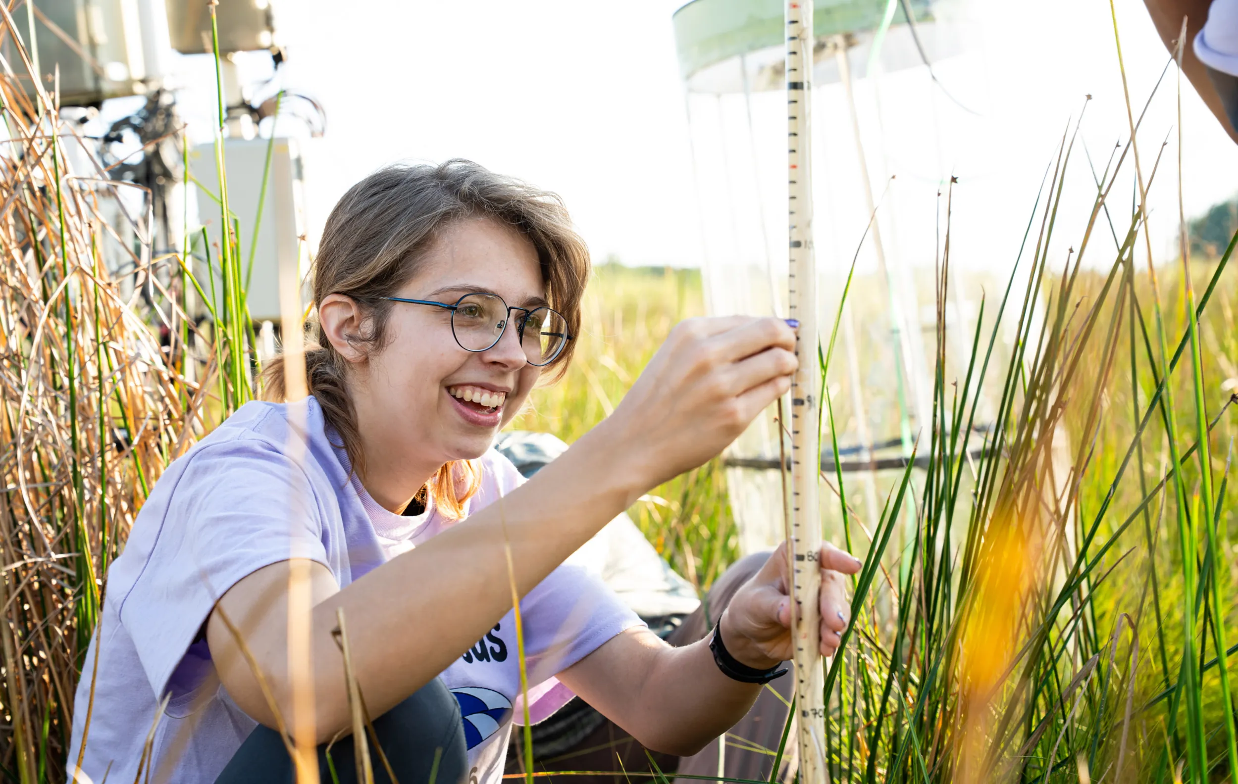 A Summer Science Biology researcher happily measures phragmites
