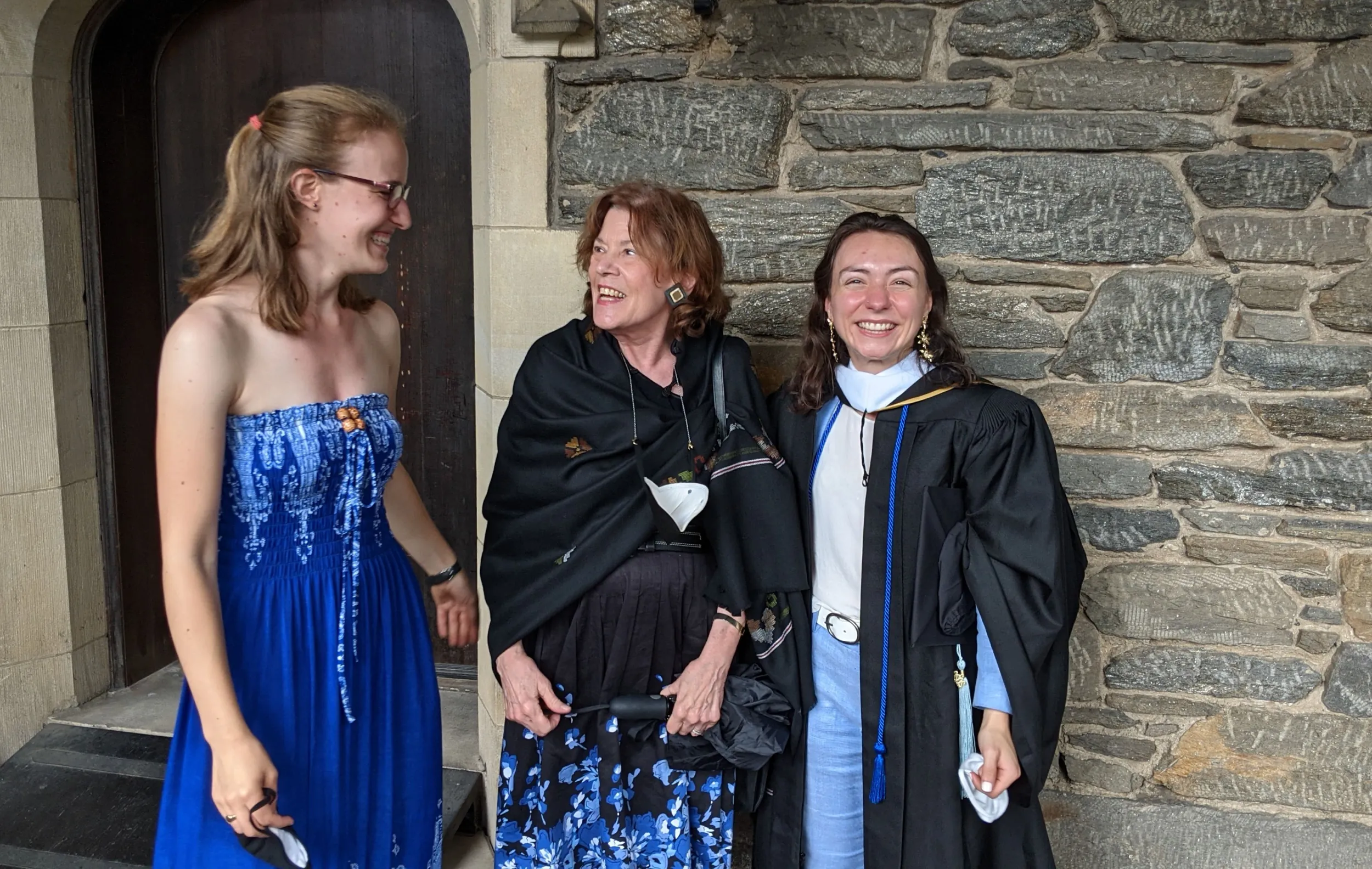 Two students and a professor at graduation