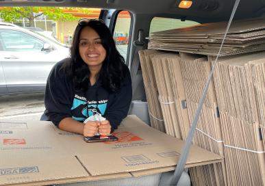 Image of student helping transport storage boxes to campus