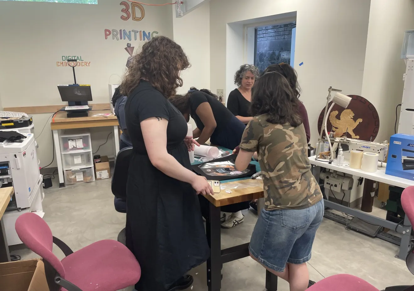 The Digital Technology Interns work with Bronwen Densmore, Makerspace Coordinator, on an introductory project for the program, creating a group tote bag