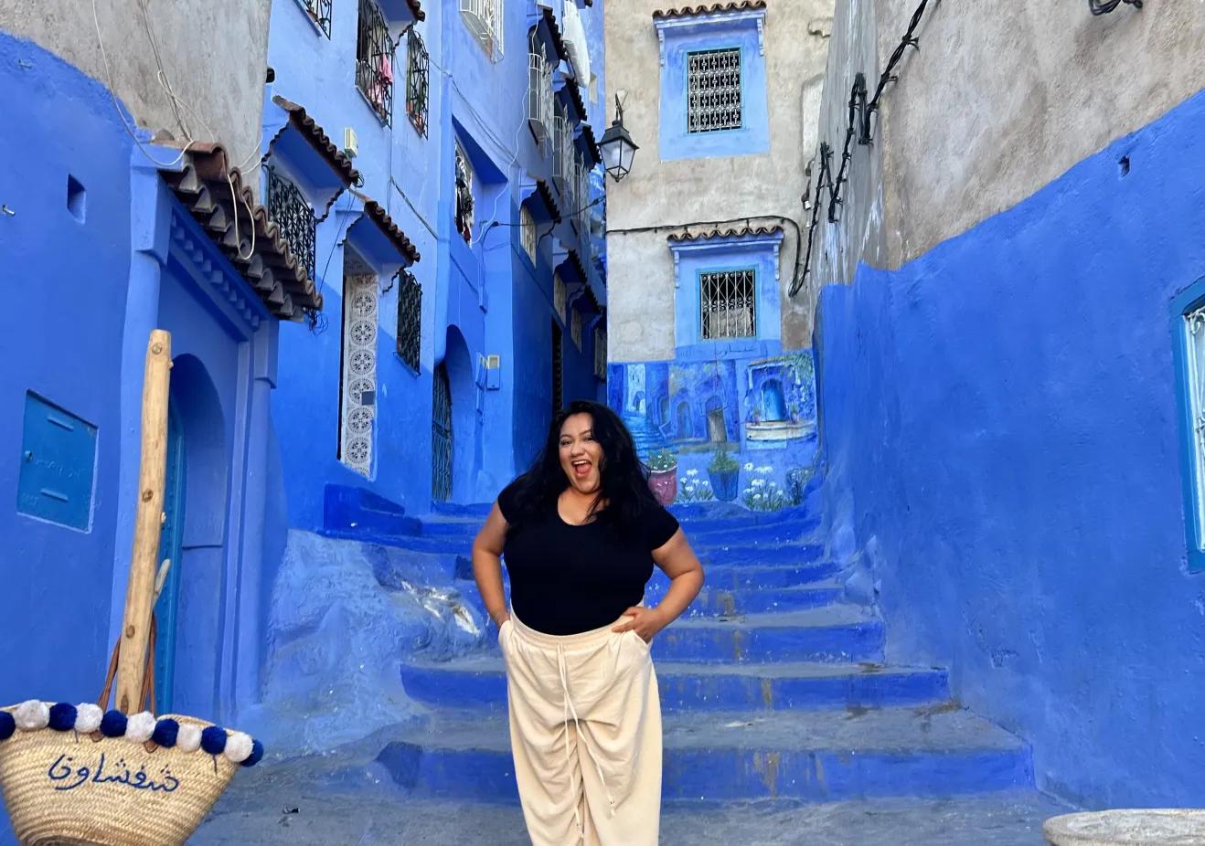 Jackie standing in at the bottom of a bright blue staircase