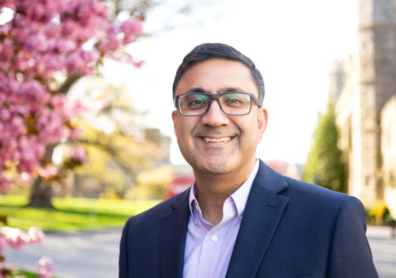 Man in a suit standing in front of a pink tree