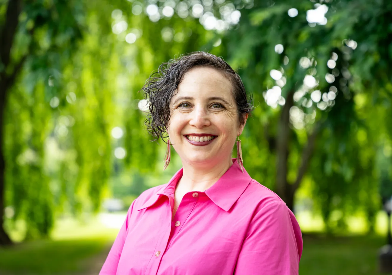 Women in pick shirt against trees