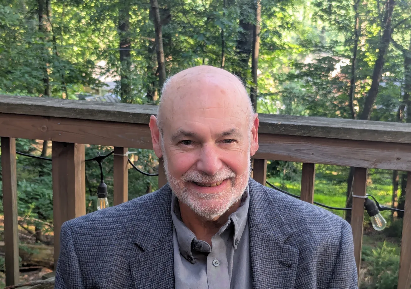 Man in suit in front of trees