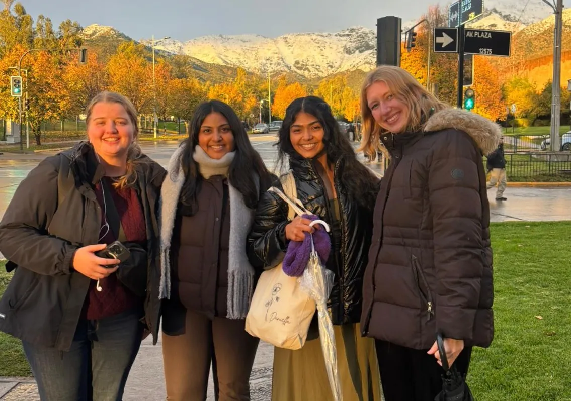 Anna and fellow interns standing on a street in front of a mountain