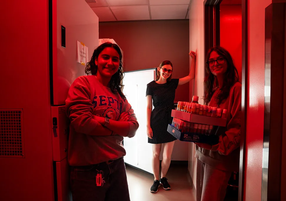 students and faculty in red lab room