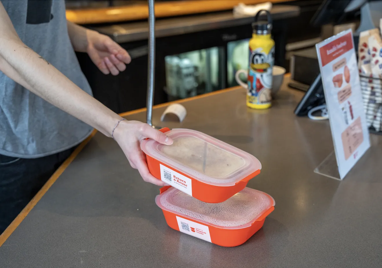 Uncommon Ground worker placing a container with food in it on a counter