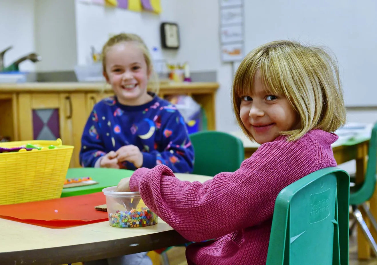 Two girls playing with beads