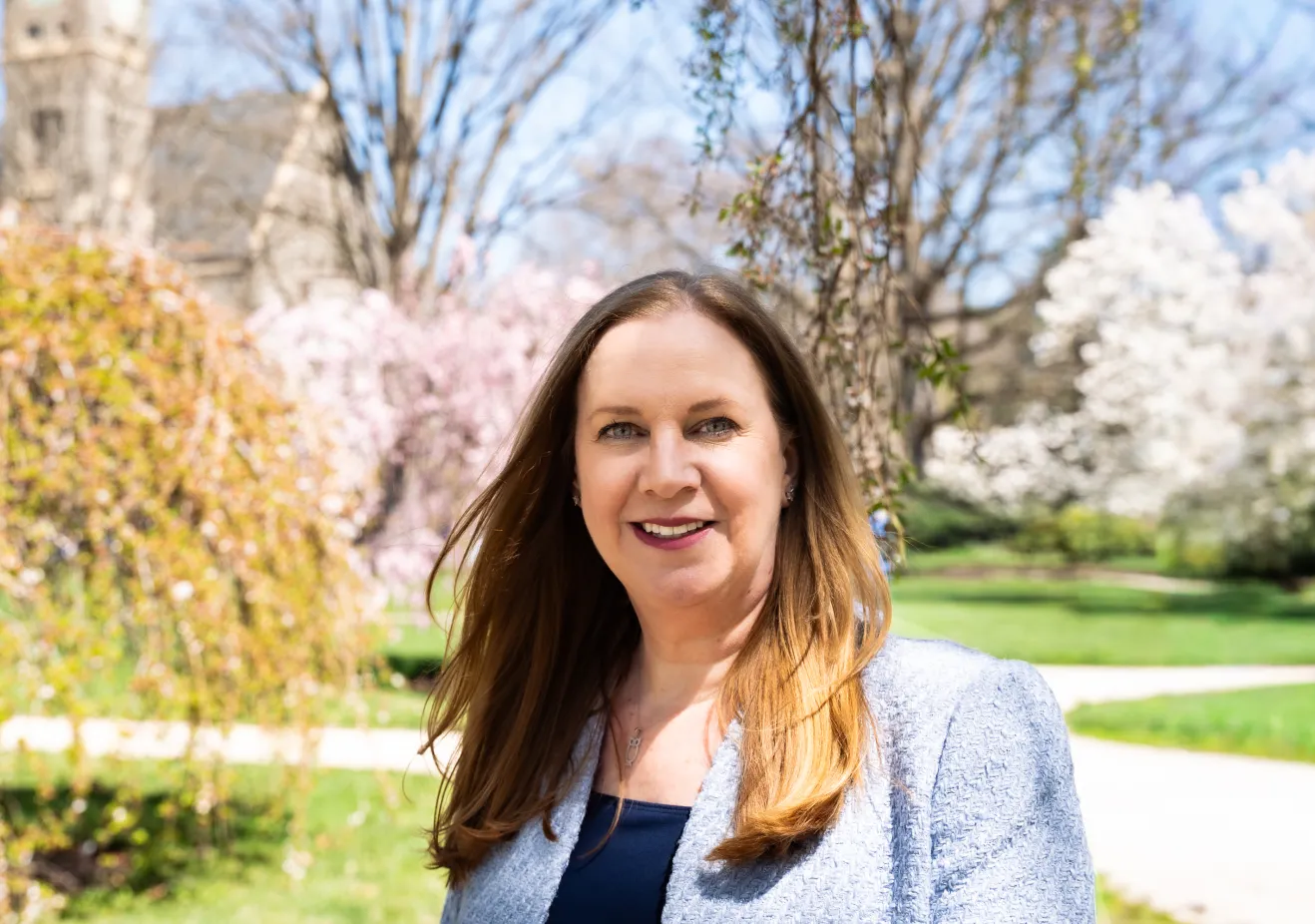 Woman standing outside with trees in distance
