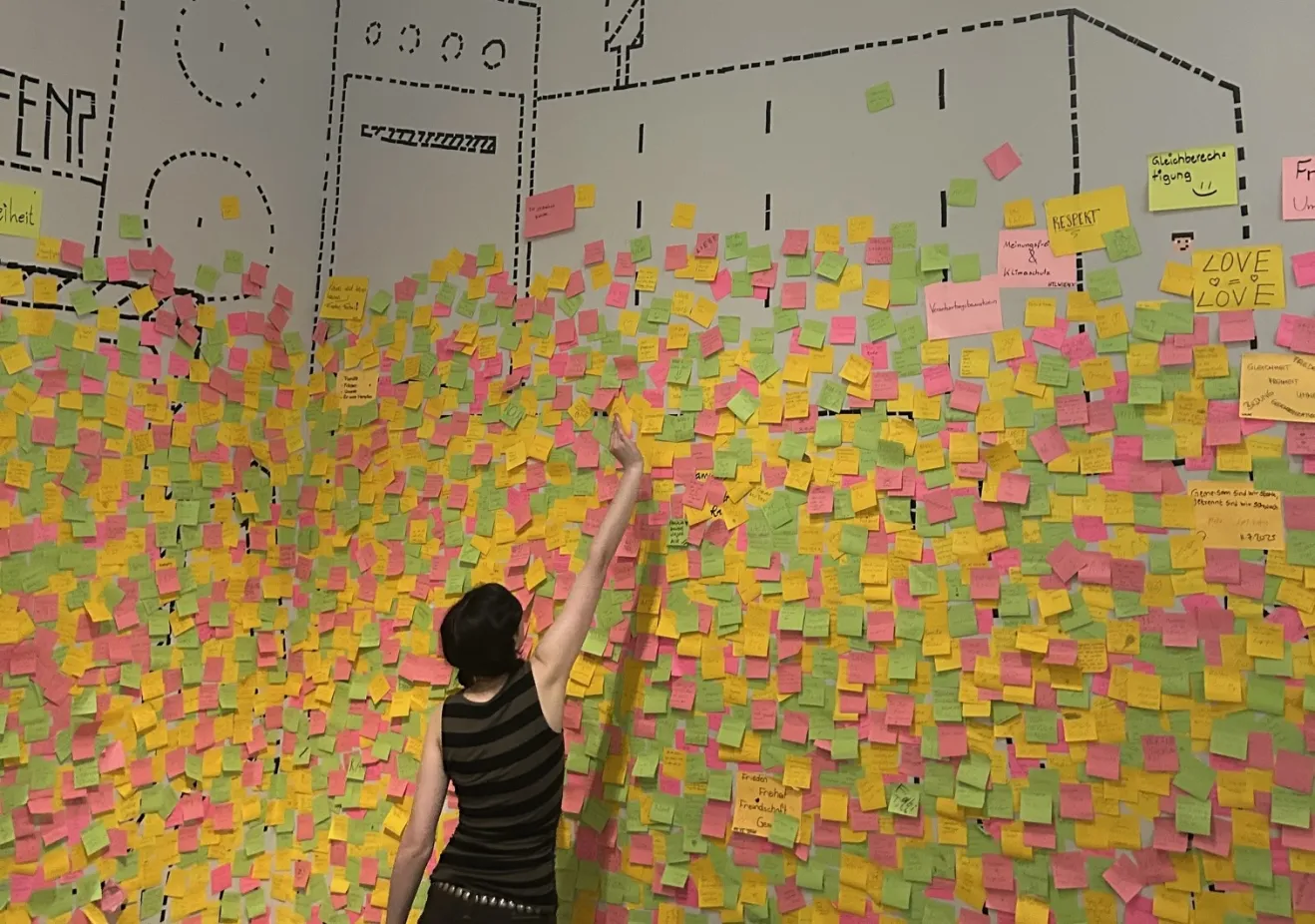 Paulina Espinosa de los Monteros ‘26 placing a sticky note on the wall of “what is worth fighting for” at the House of Austrian History Museum.