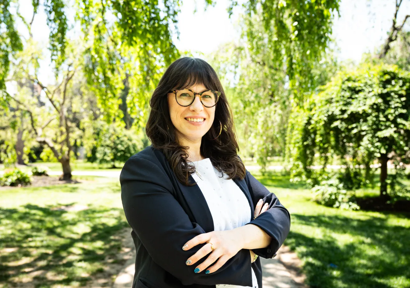 Woman in black blazer and white shirt outside 