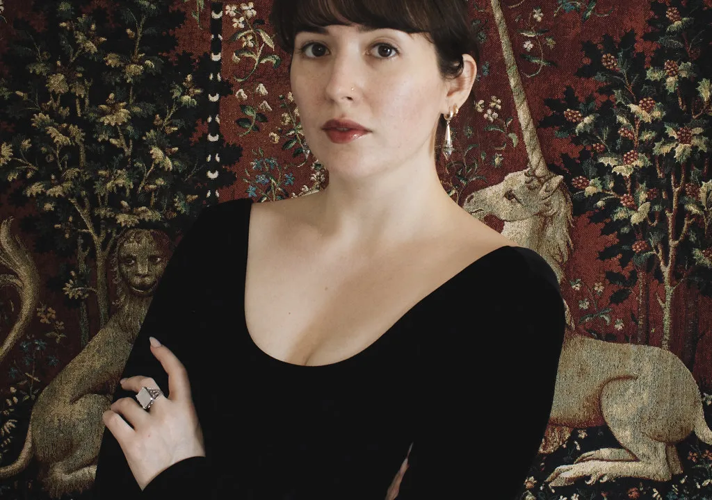 Image of Danielle Pigeon in front of a tapestry