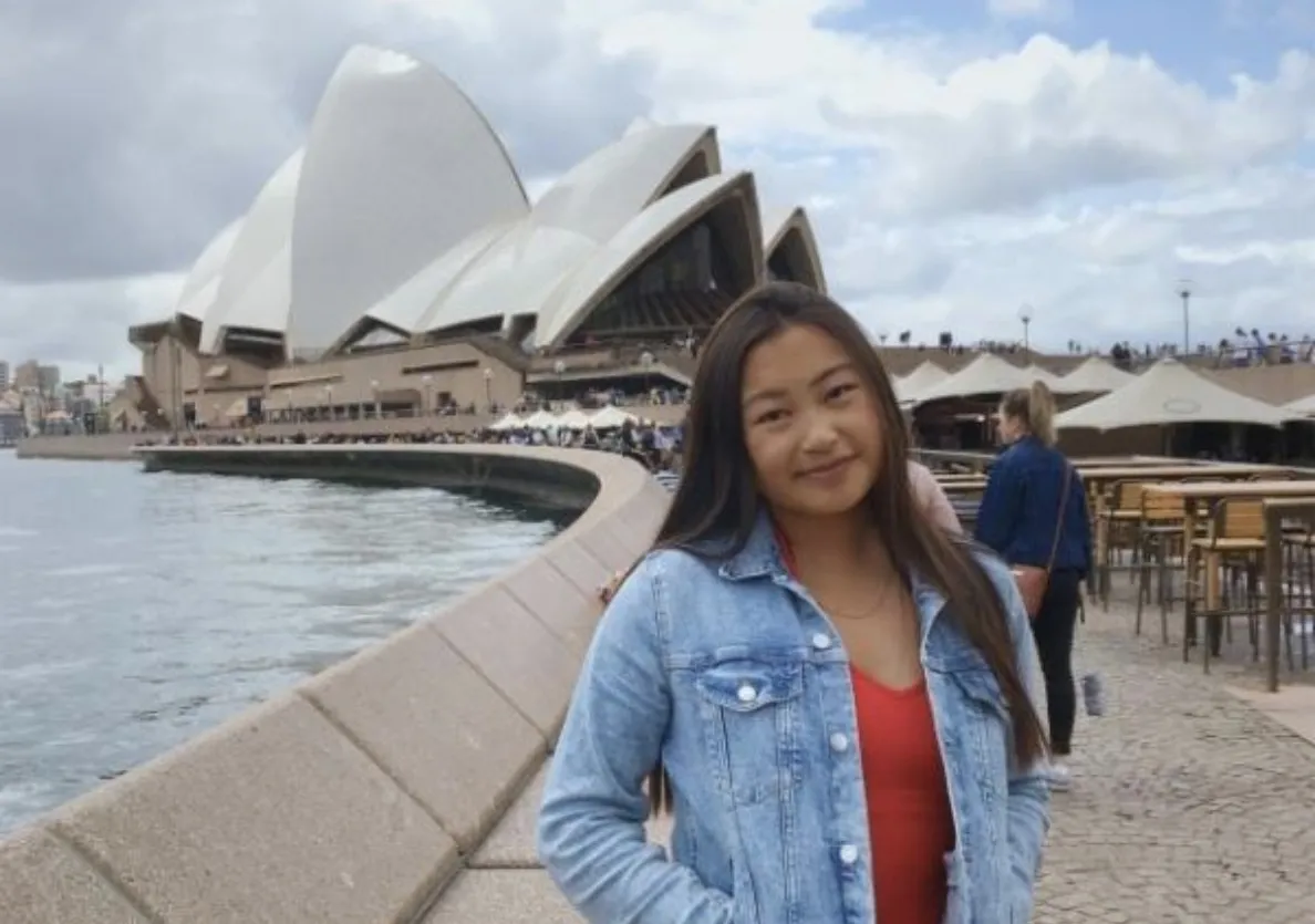 A Bryn Mawr College student abroad stands in from of the Sydney Opera House