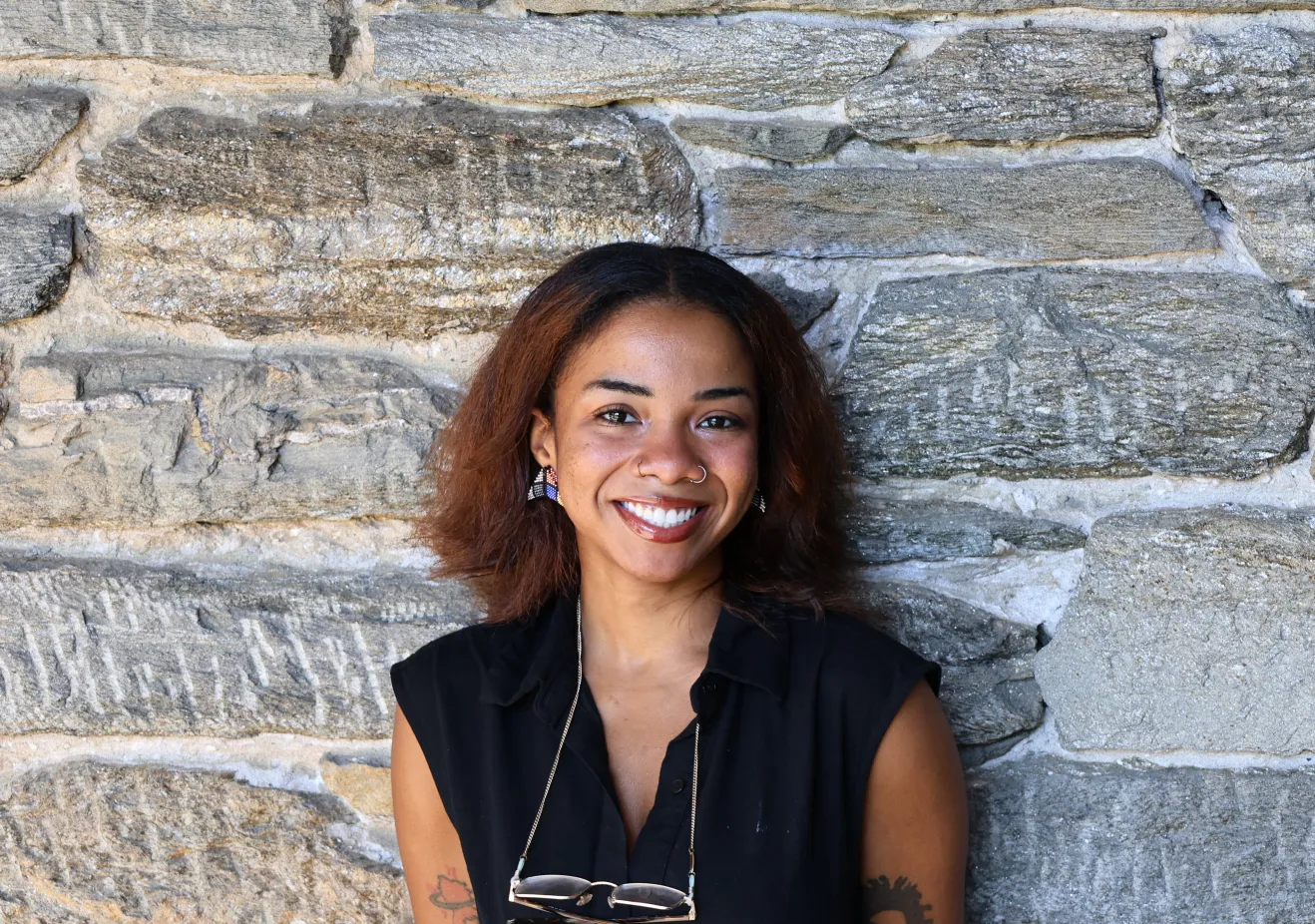 Venus Myrick poses in front of a stone wall