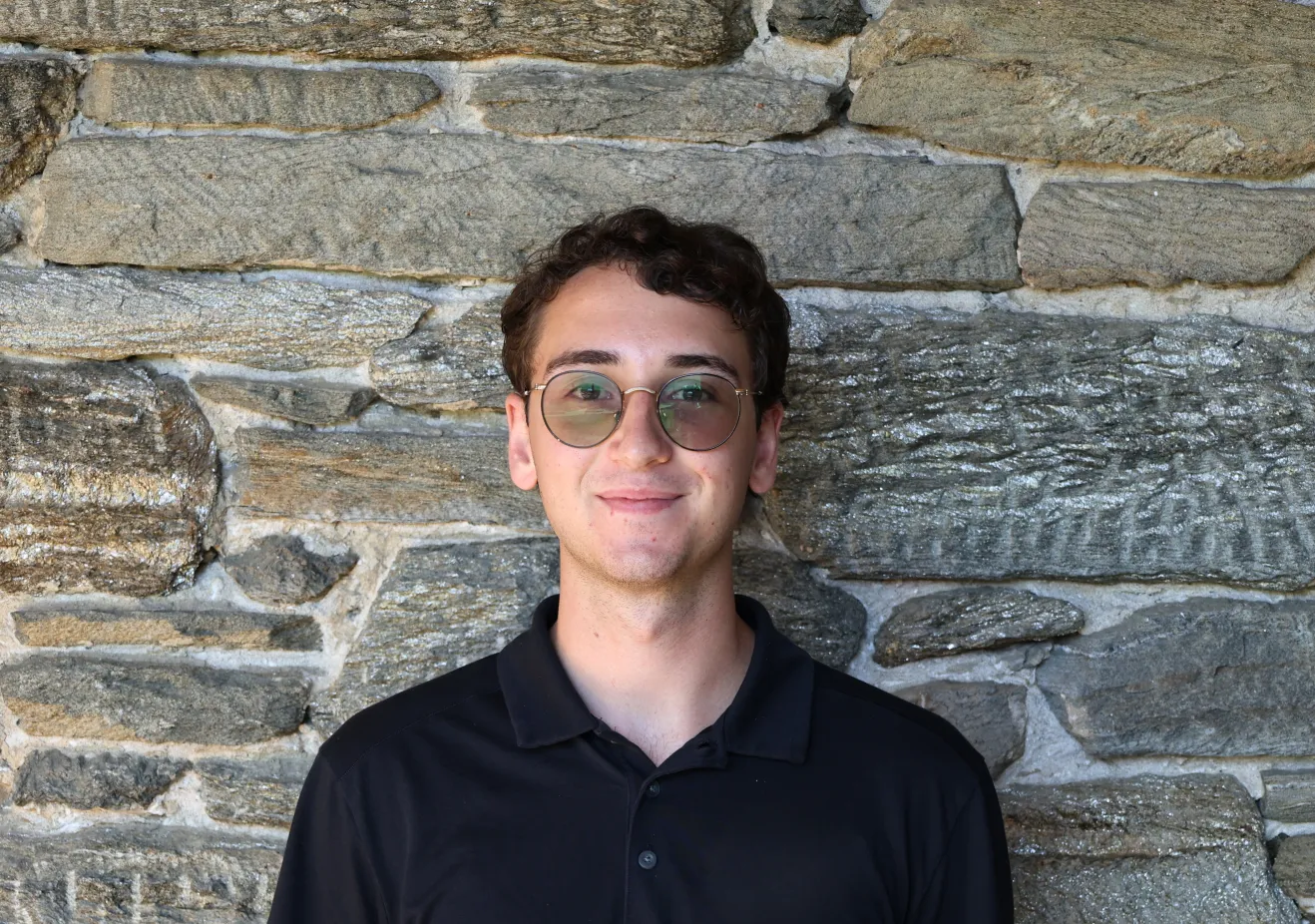Nick Chlanda poses in front of a stone wall