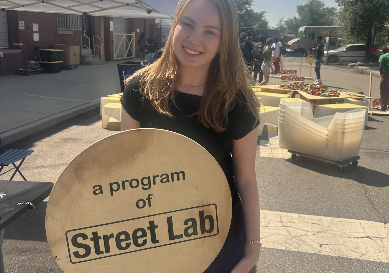 Anna standing with a Street Lab sign