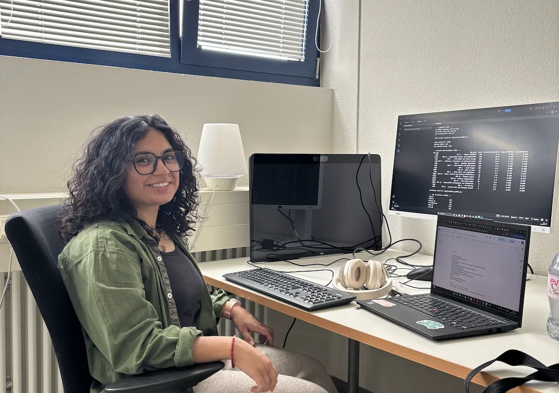 Ali sitting in front of a computer monitor