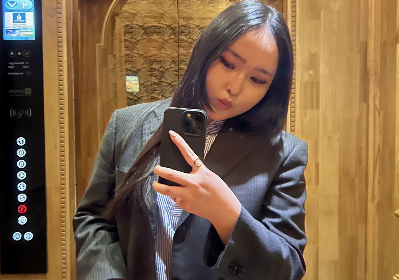 Solongo taking a photo in a mirror in an office building