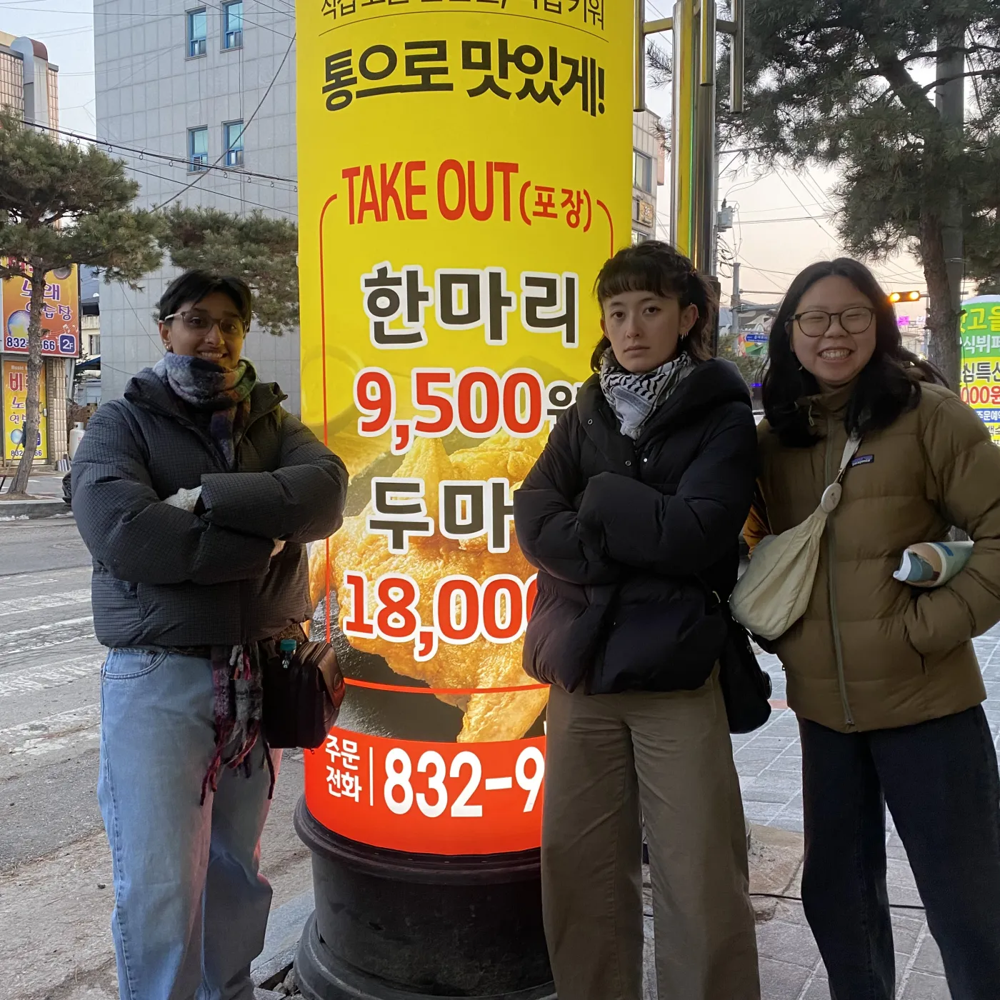 Roma and friends standing by a Korean language sign
