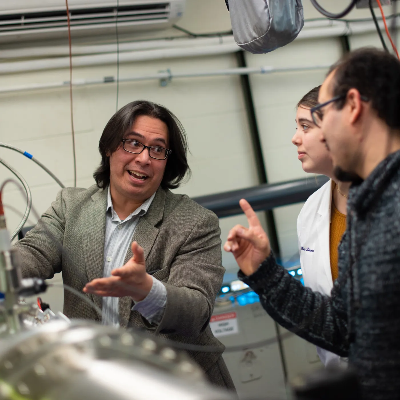 A professor talks animatedly about how excited he is about plasma physics equipment