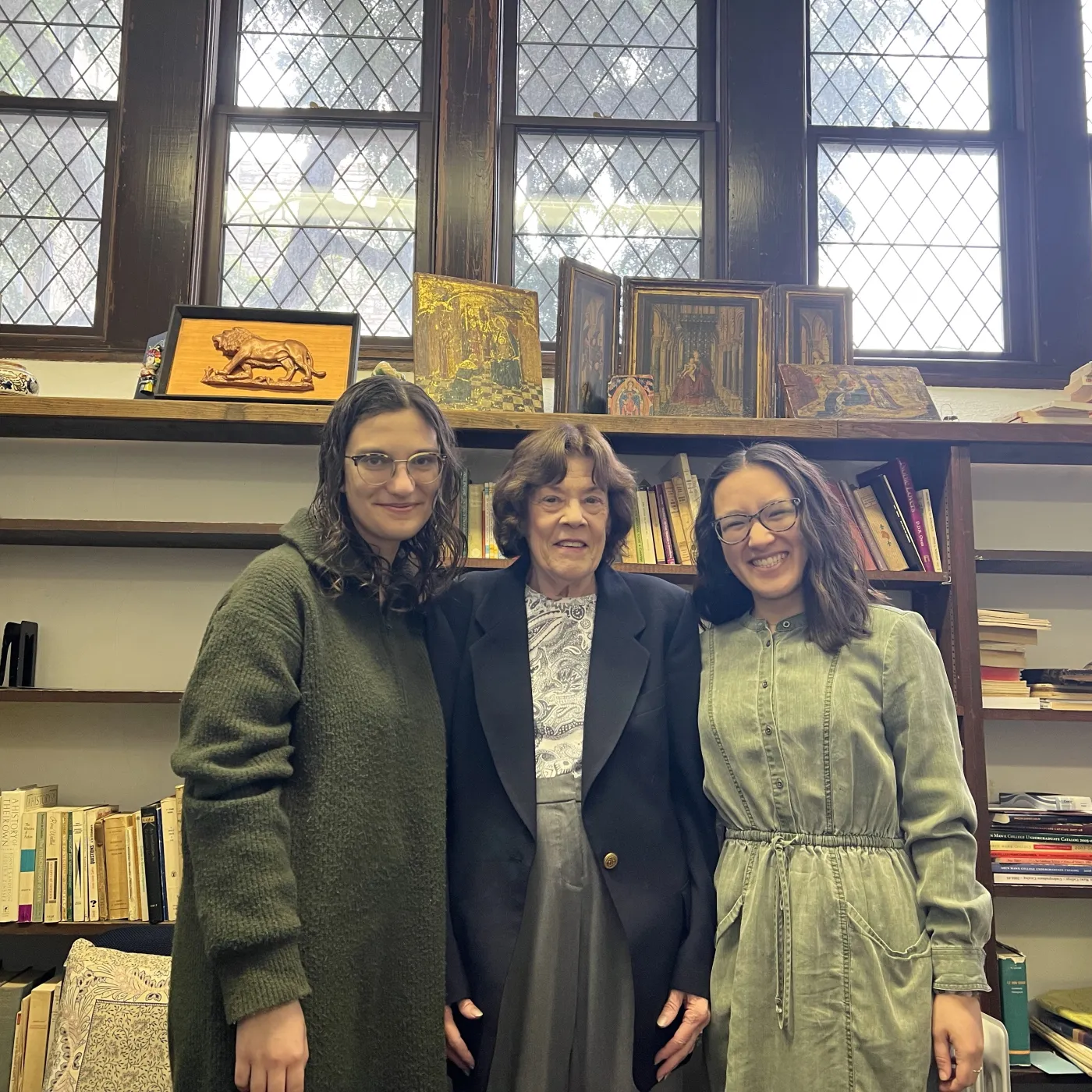 Two students and a professor in an office in Old Library, smiling at the camera